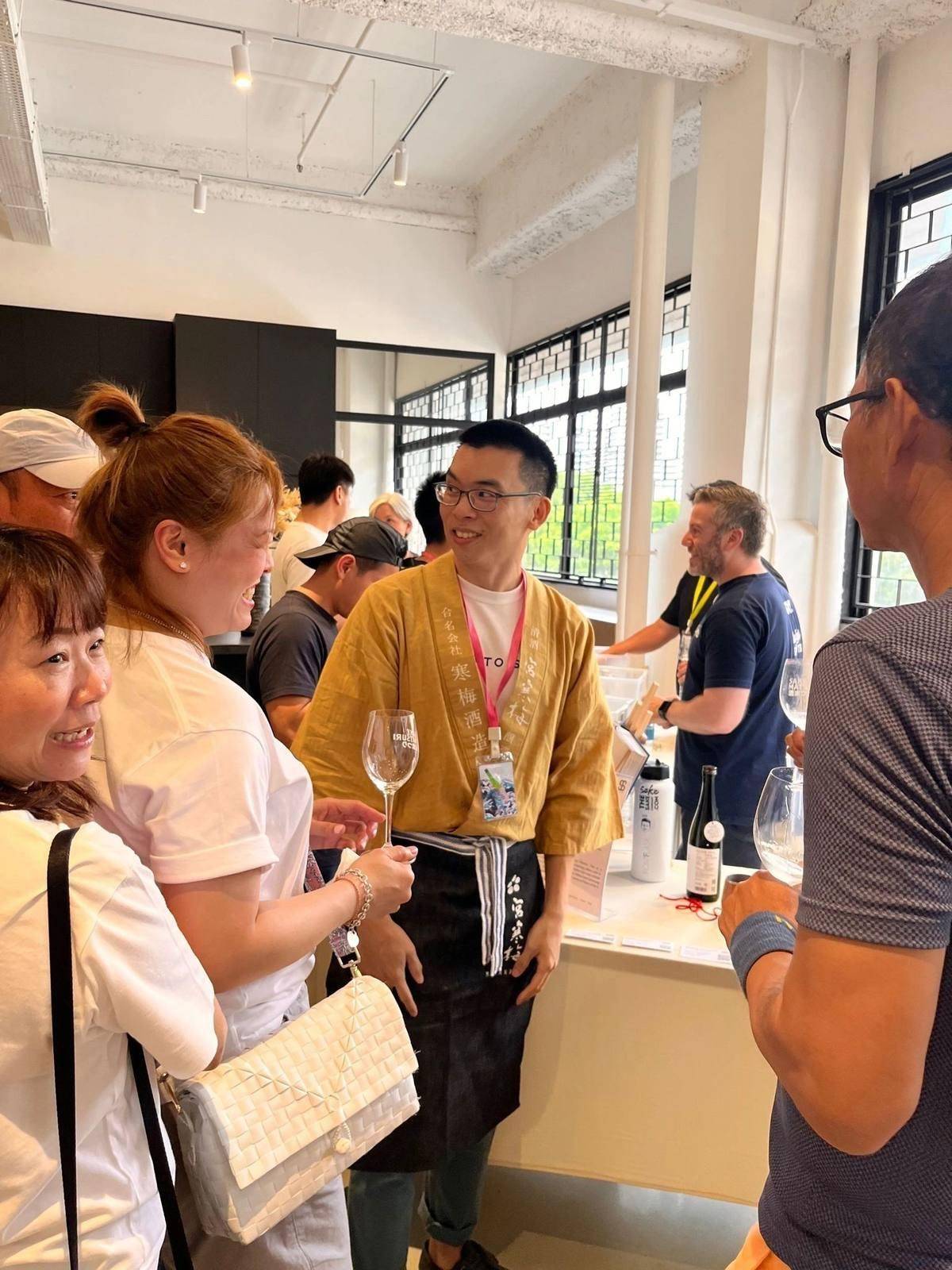 Hansel pouring sake for guests at a tasting